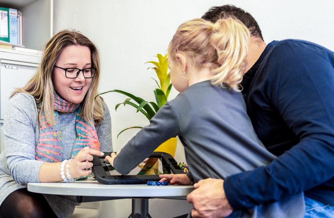 Eine Beraterin steht dem Pflegevater und Kind bei (Foto: iStock.com, AndreaObzerova)